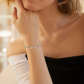 Delicate silver bracelet featuring leaf charms on a 14k Gold Plated Moissanite Diamond Bracelet