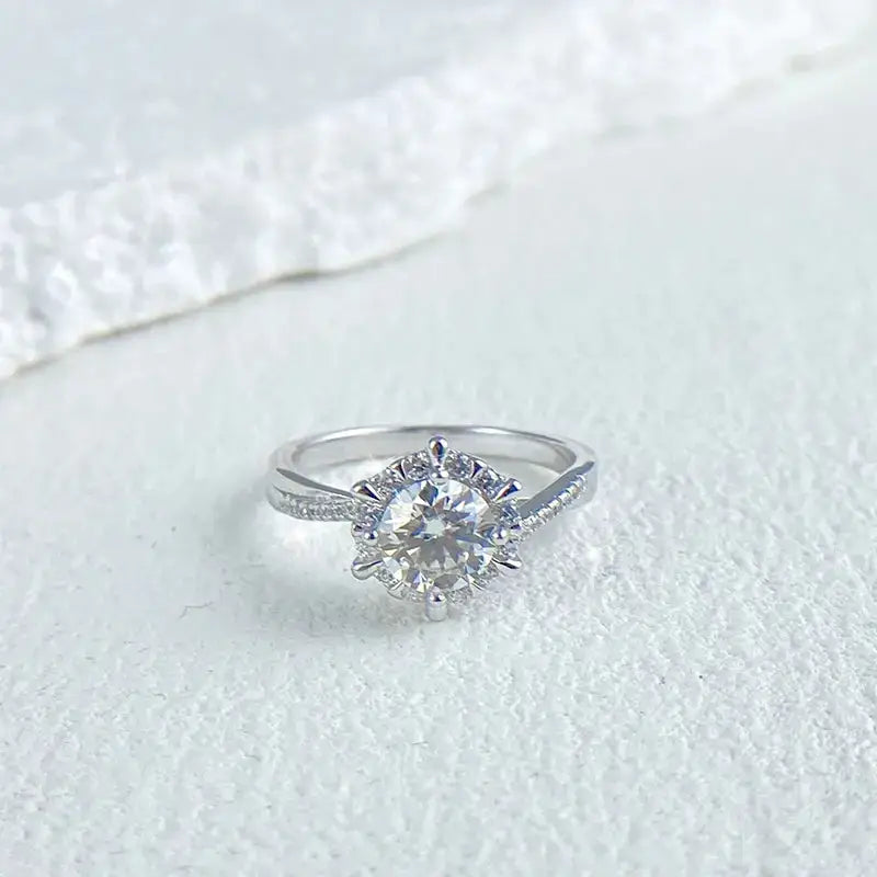 Diamond engagement ring featuring a round center stone in 18k white gold floral setting