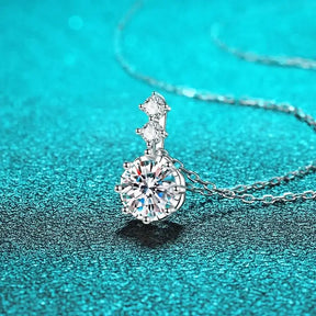 Diamond pendant necklace featuring a round brilliant-cut Moissanite stone and accent diamonds