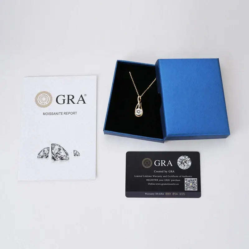 Gold necklace with a teardrop-shaped lab grown diamond pendant in a blue jewelry box