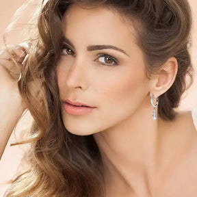 Woman with long brown hair showcases 3.6CTW D VVS1 Moissanite Diamond hoop earrings