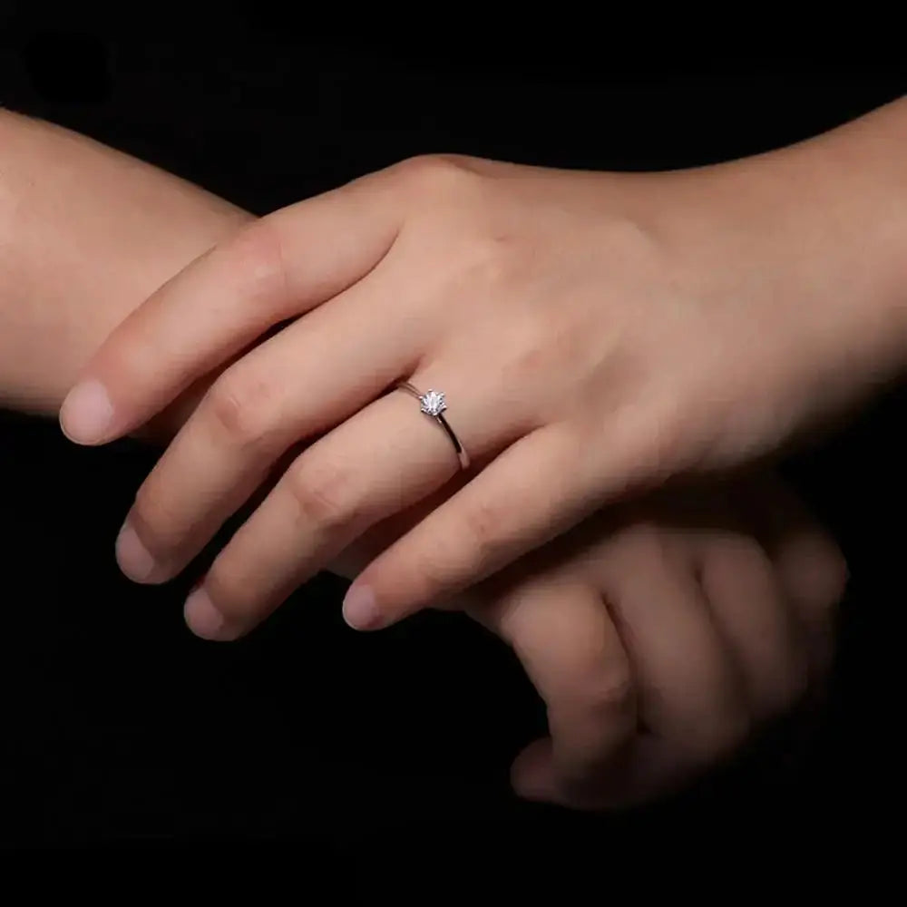 Diamond engagement ring on a woman’s hand showcasing an elegant 18k gold moissanite silver ring