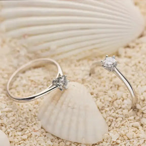 Delicate diamond solitaire engagement rings on a seashell with 4mm Moissanite Silver Ring