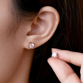 Elegant 5mm Lab Grown Diamond Earrings held near an ear showcasing their brilliance