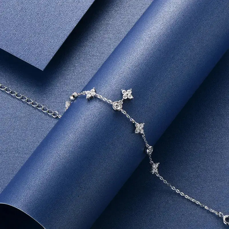 Delicate silver bracelet featuring star-shaped diamond accents in a four leaf clover design