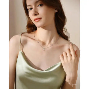 Young woman in satin camisole showcasing Silver Four Leaf Clover Jewelry Set