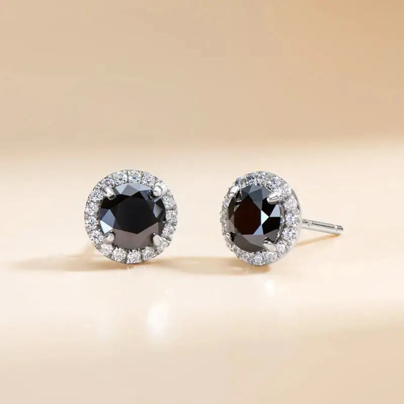 Pair of diamond stud earrings with black center stones and white diamonds in Telles Jewelry set