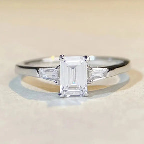 Elegant engagement ring with emerald cut moissanite and baguette diamonds in sterling silver