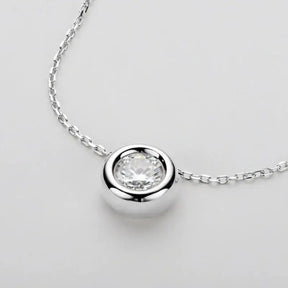 Silver pendant necklace showcasing a round cut moissanite gemstone in sterling silver