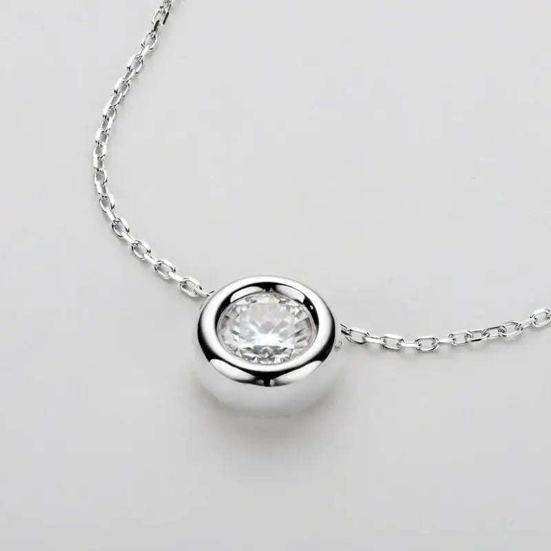 Silver pendant necklace showcasing a round cut moissanite gemstone in sterling silver