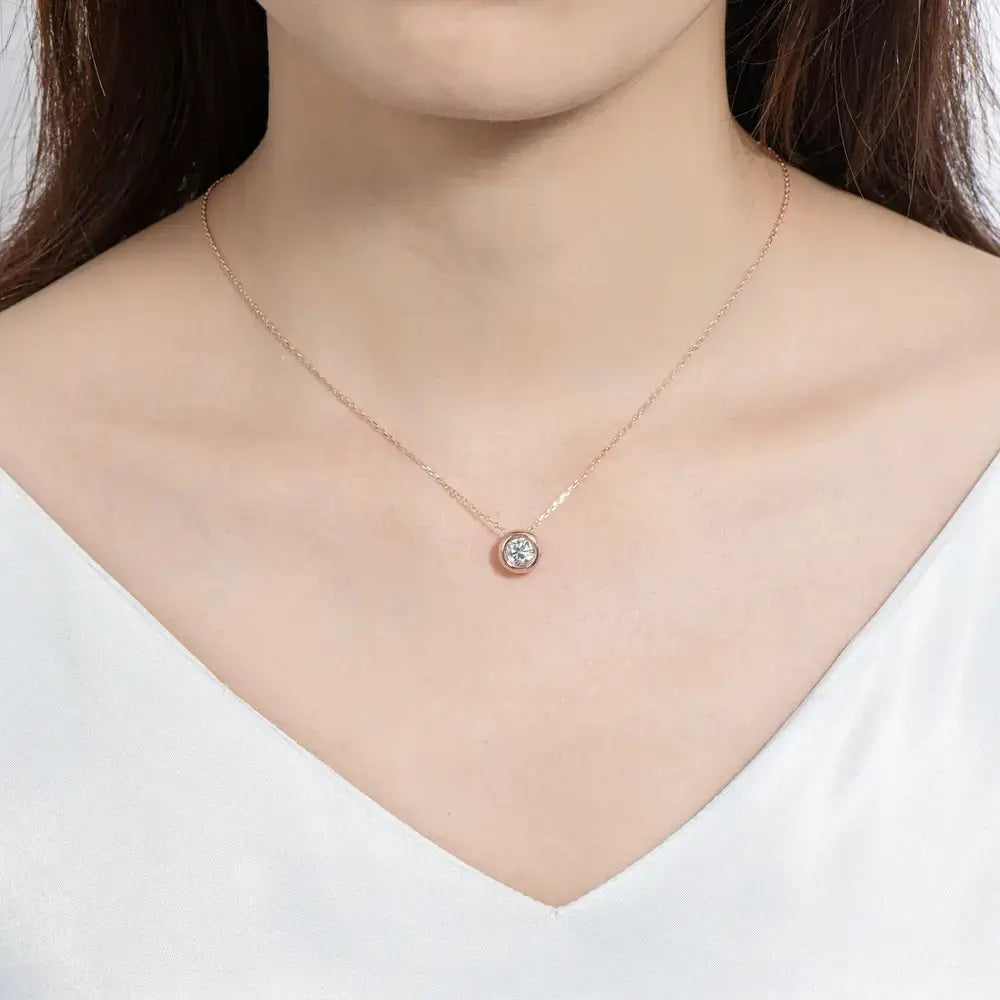 Delicate sterling silver necklace featuring round cut moissanite gemstone pendant