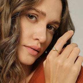 Close-up of a woman with wavy hair showcasing a Bezel Moissanite Ring in silver