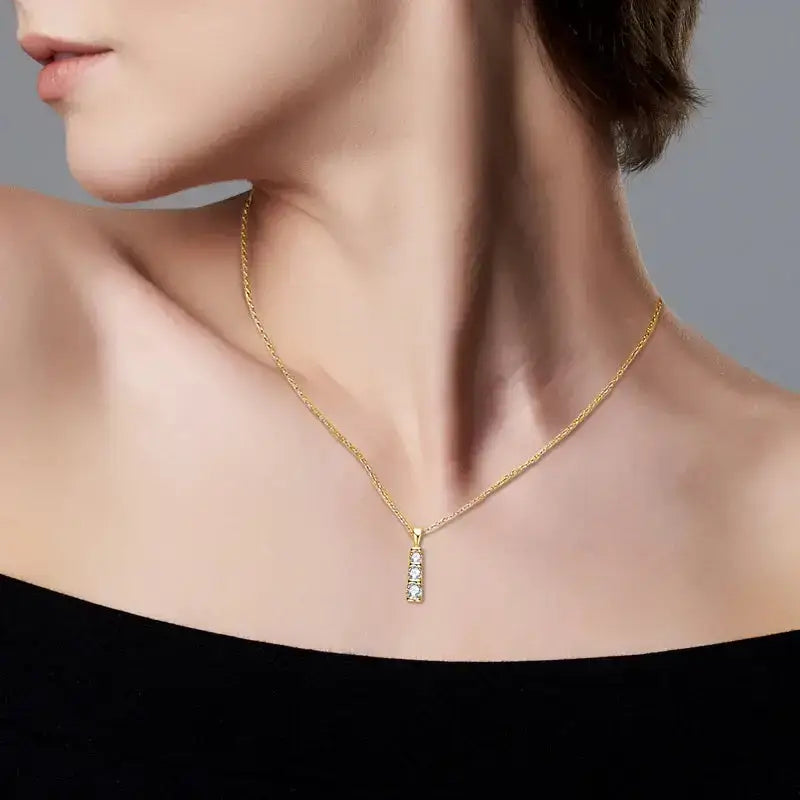 Gold necklace with a delicate pendant showcasing three moissanite stones in sterling silver