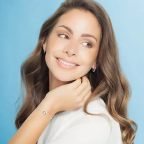 Smiling woman in white top showcasing Elegant Infinity Bracelet with Lab Grown Diamond