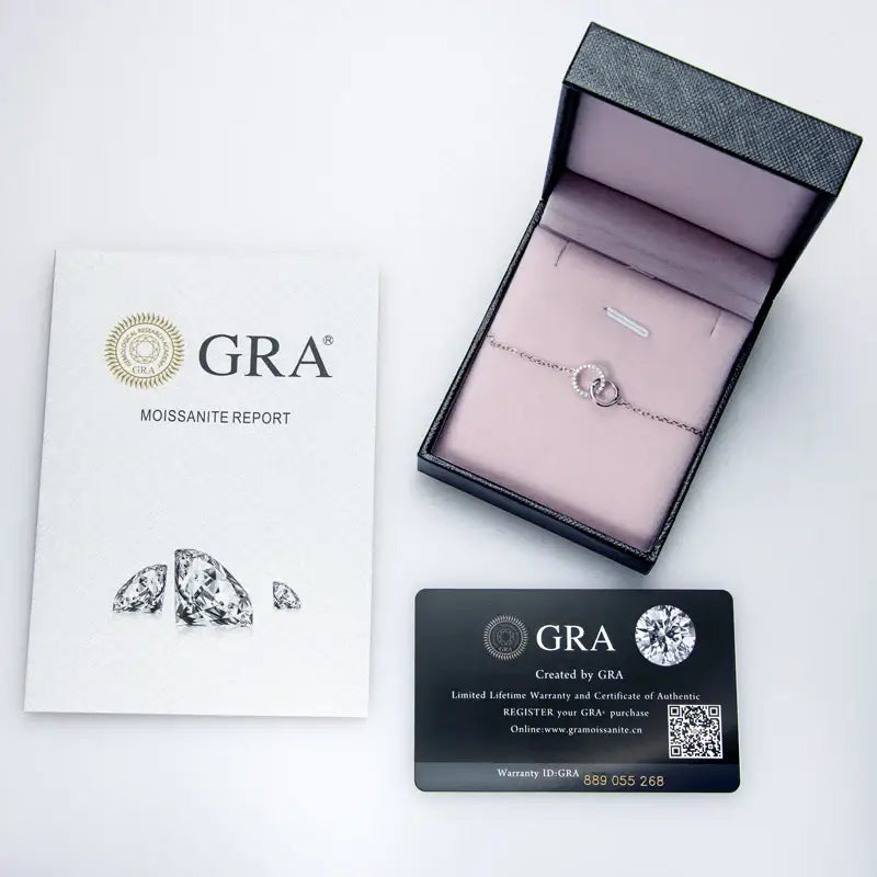 Delicate diamond ring in jewelry box with GRA documents and Elegant Infinity Bracelet