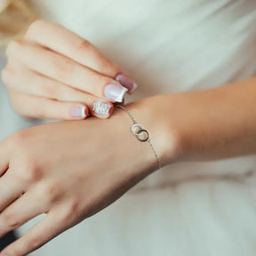 Delicate silver bracelet with circular charm on wrist features Elegant Infinity Bracelet with Lab Grown Diamond