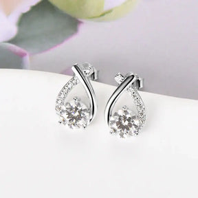 Teardrop-shaped diamond stud earrings in curved silver settings, perfect for trendy wear