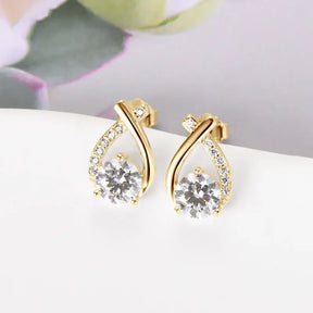 Gold teardrop-shaped diamond earrings featuring fishtail cross diamond accents