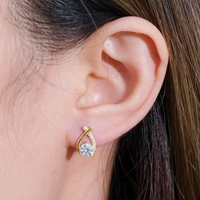 Gold teardrop earrings adorned with diamonds from the Fishtail Cross Diamond collection