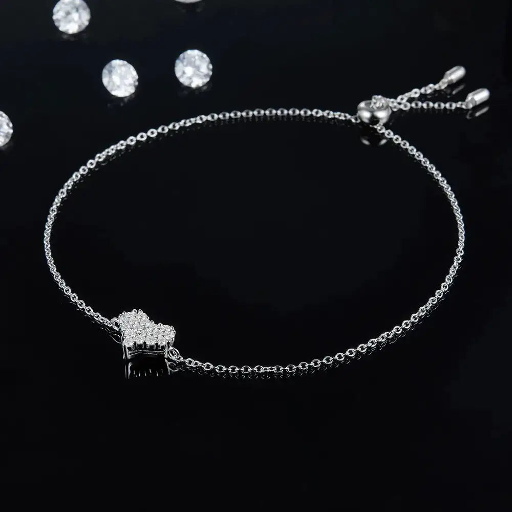 Delicate silver bracelet with heart charm accented by elegant Moissanite diamonds