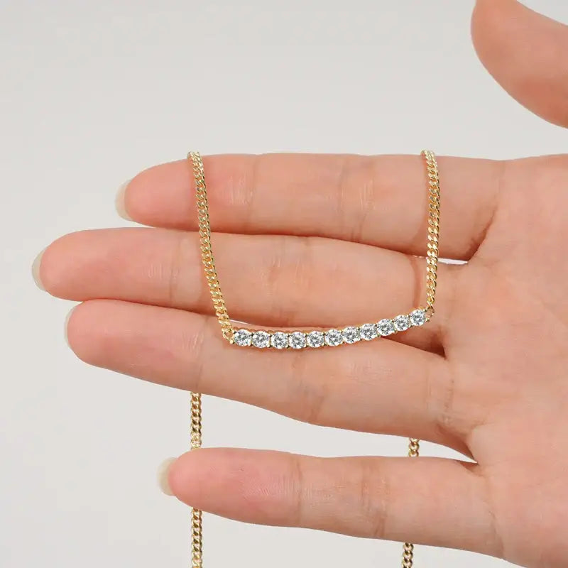 Gold necklace with curved bar pendant, showcasing lab grown diamond accents, elegant design