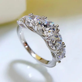 Moissanite wedding ring featuring five round brilliant-cut stones in sterling silver band