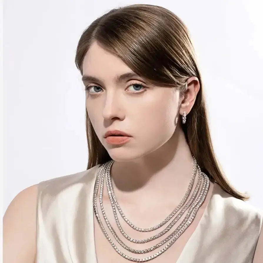 Young woman showcasing an elegant 18K gold Moissanite diamond tennis necklace and pearl earrings