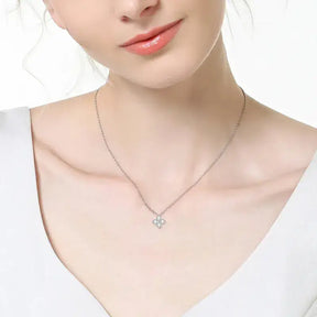 Delicate sterling silver necklace with a four-leaf flower pendant and gemstones