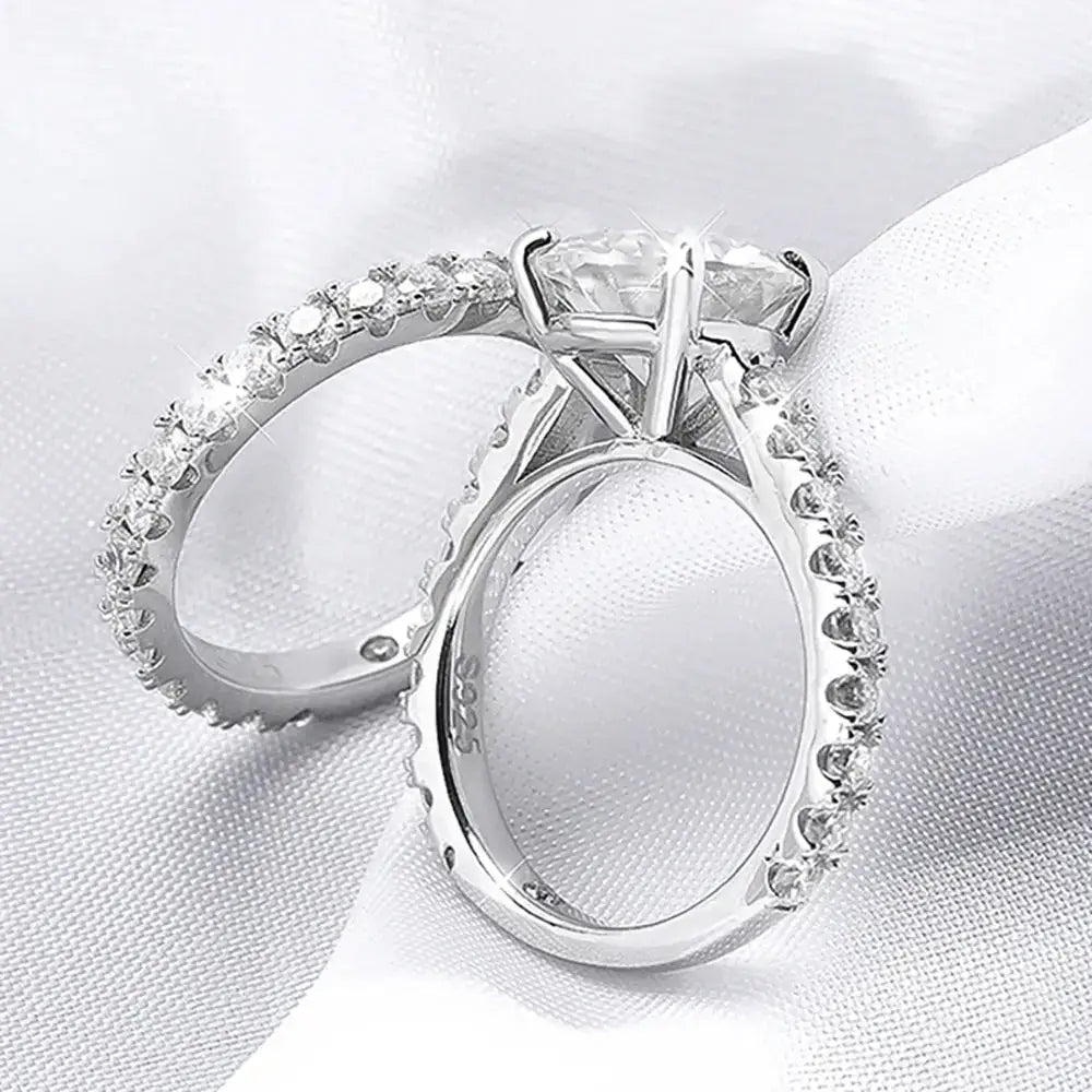 Diamond engagement ring features a Moissanite center stone and pave band in sterling silver