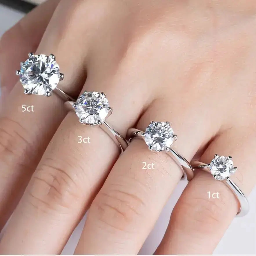 Four Moissanite engagement rings in 925 Sterling Silver Gold Plated on a hand