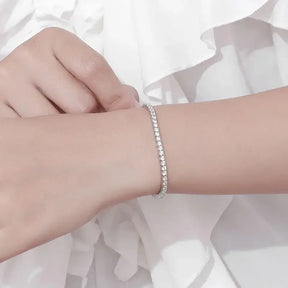 Delicate Moissanite tennis bracelet in white gold elegantly worn on a wrist