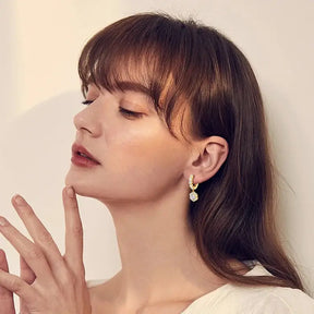 Woman with bangs showcasing New Women’s Hoop Earrings with Lab Grown Diamond Drop