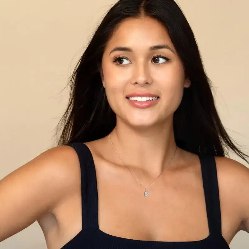 Young woman smiling while wearing an Oval Lab Grown Diamond Halo Pendant Necklace