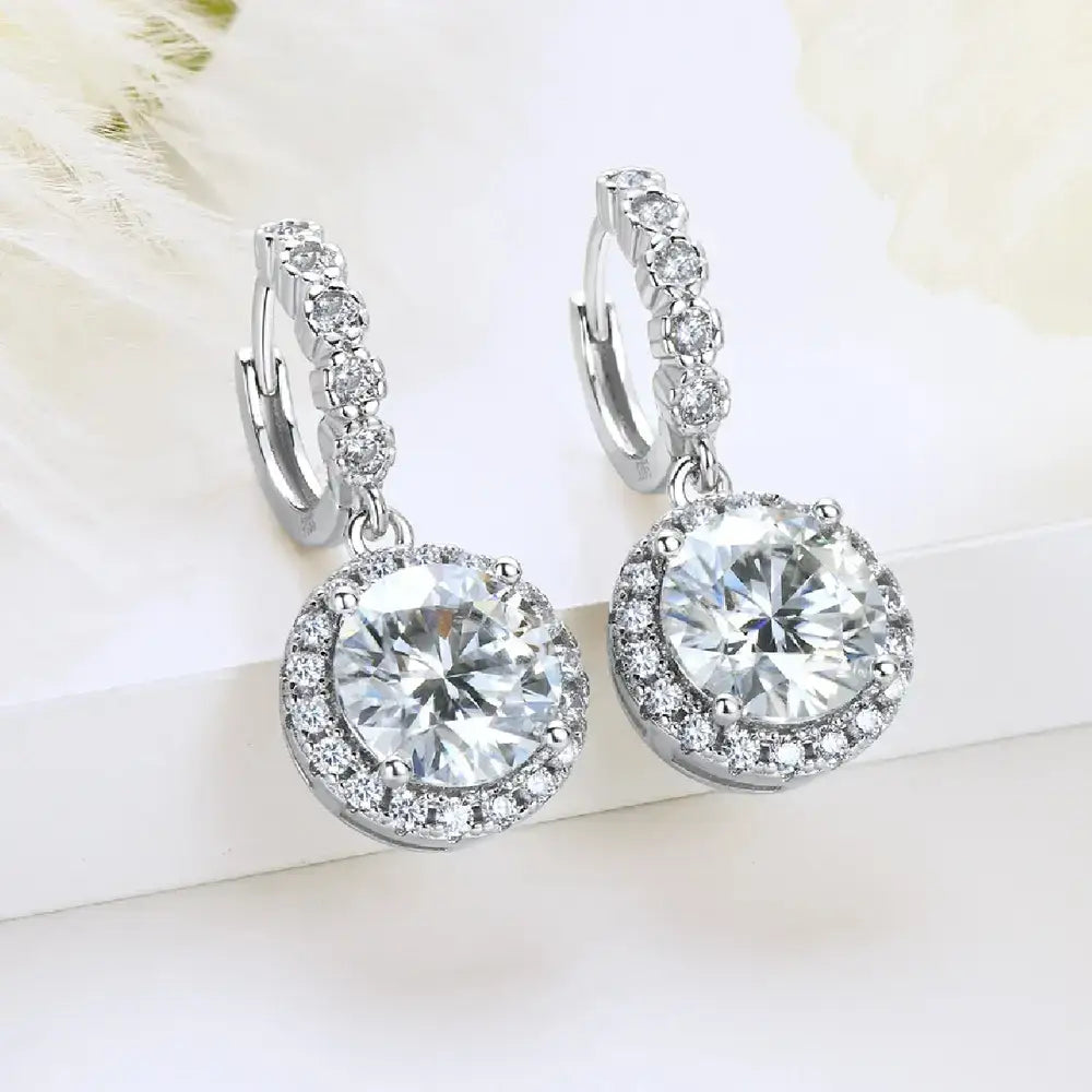 Pair of moissanite drop hoop earrings with diamond halo setting and round center stones