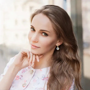 Young woman in a floral top wearing Moissanite drop hoop earrings in 925 silver