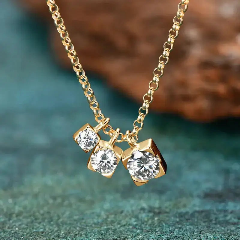 Gold necklace featuring three cubic zirconia pendants, showcasing timeless elegance