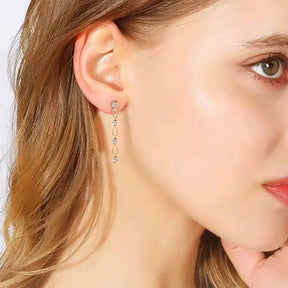 Delicate gold dangle earrings featuring small crystal accents and a bezel 3mm lab grown diamond