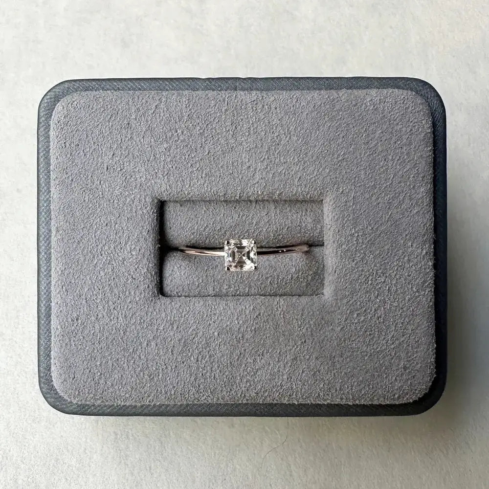 Diamond solitaire engagement ring in gray velvet box featuring Asscher cut Moissanite