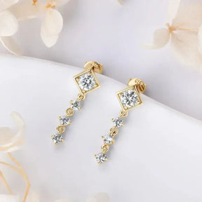 Gold dangle earrings with diamond-shaped crystals in a linear design, moissanite drop elegance