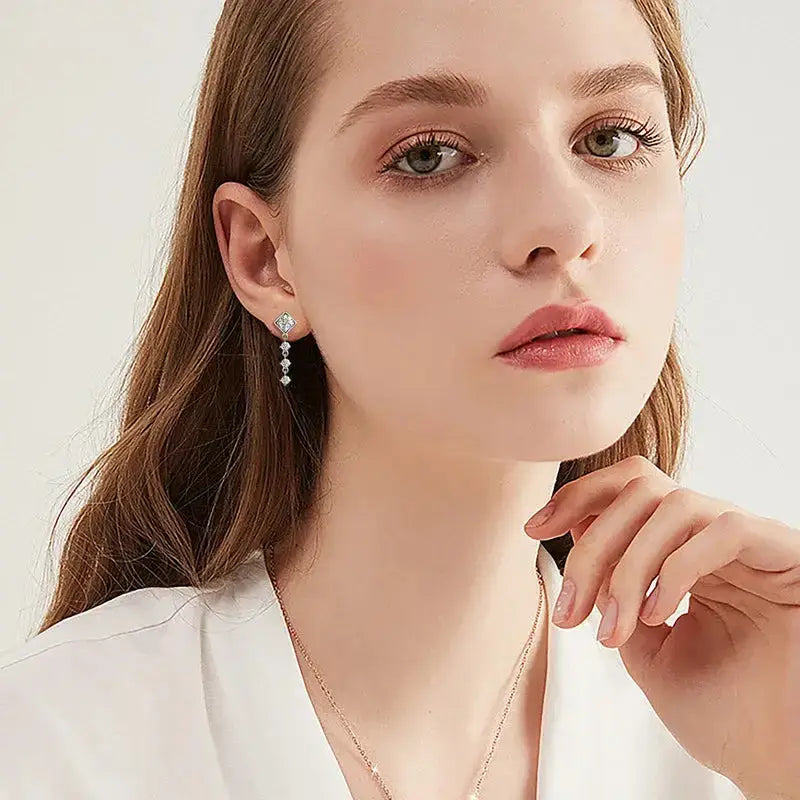 Close-up portrait of a young woman showcasing Square Moissanite Drop Earrings in elegant style