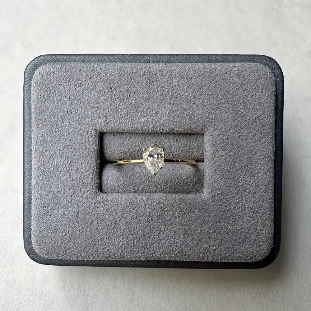 Pear-shaped moissanite diamond ring in gray box, a perfect sterling silver pear anniversary gift