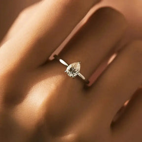 Diamond engagement ring featuring pear-shaped moissanite diamond in sterling silver setting