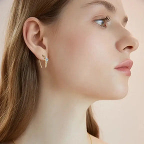 Profile view of a person wearing U Shaped 3 Stone Moissanite Earrings in elegant silver