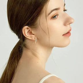 Profile view of a young woman with brown hair showcasing U Shaped Moissanite Earrings