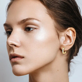 Side profile of a person wearing versatile C shape open earrings with gold and diamonds