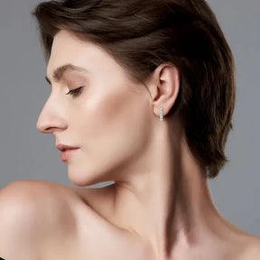 Profile view of a woman wearing versatile C shape open earrings with lab grown diamonds